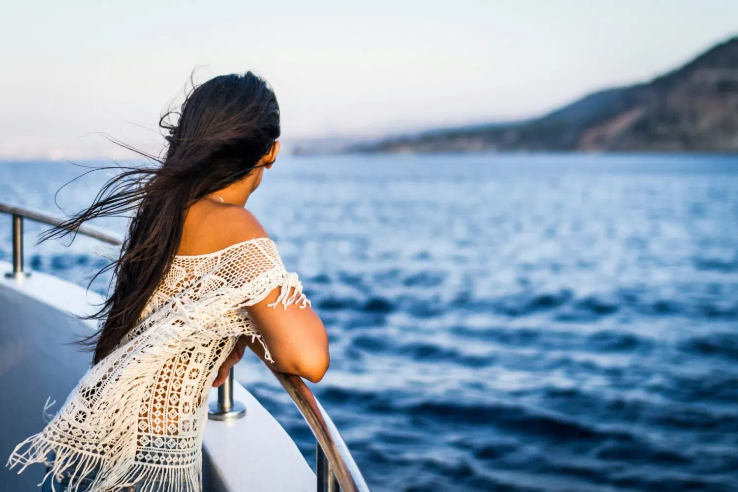 A guest at the rail looking out to sea on a day at sea